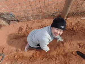Deer Hill participant at Service smiling in the dirt